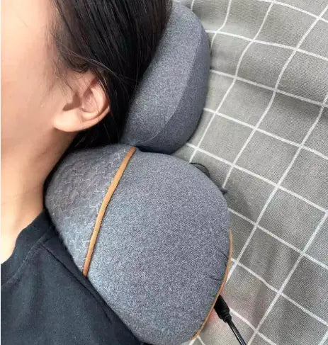 Person using a gray travel neck pillow on a checkered fabric surface